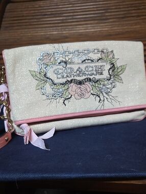 COACH Cream Canvas Wristlet with Pink Trim and Floral Logo